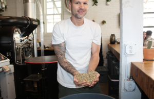 Jon Allen holds coffee beans at his Onyx Coffee house in Rogers.&nbsp;