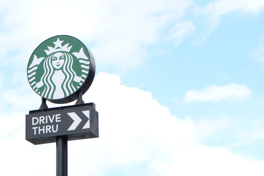 A Starbucks drive-through sign with a blue sky background