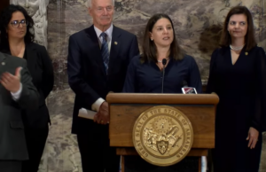 Alison Williams, standing behind a podium at the Arkansas State Capitol, speaks about the release of the 2022 Arkansas Women's Commission report on women in the labor market and economy.