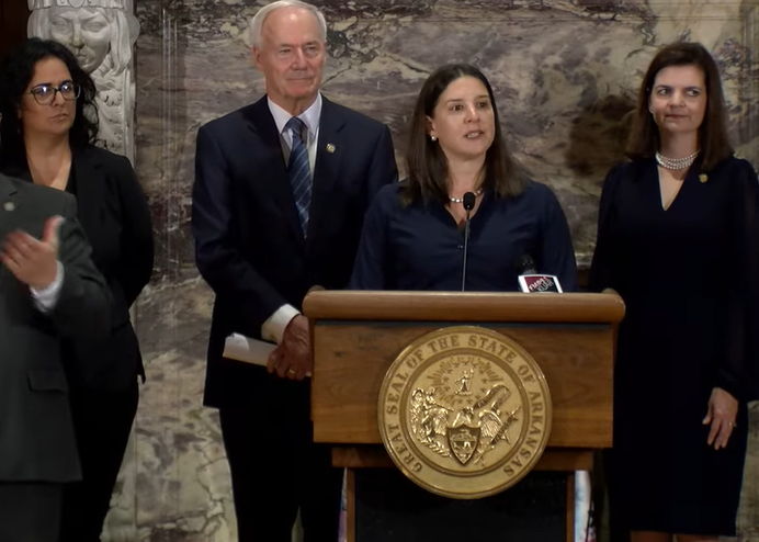 Alison Williams, standing behind a podium at the Arkansas State Capitol, speaks about the release of the 2022 Arkansas Women's Commission report on women in the labor market and economy.