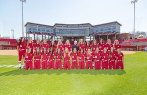 Susie Everett of Everett Automotive Group, surrounded by the UA softball team, with which the group has an NIL deal.