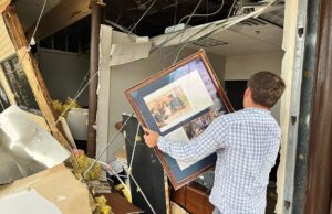 Jake Keet examines tornado damage at the Breckenridge Village shopping center in Little Rock on March 31, 2023