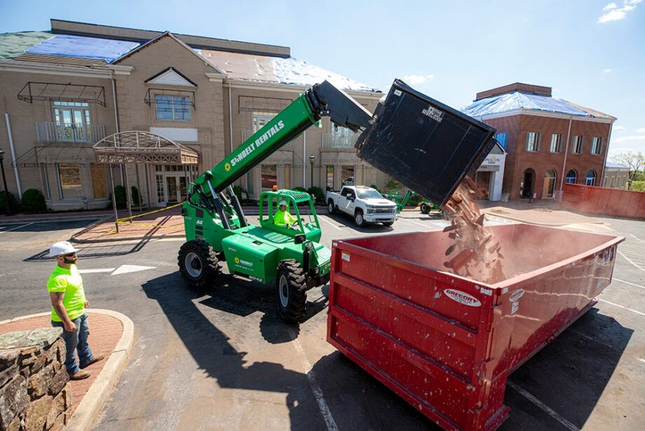 Workers remove pieces of the tornado-ravaged roof at Pavilion in the Park.