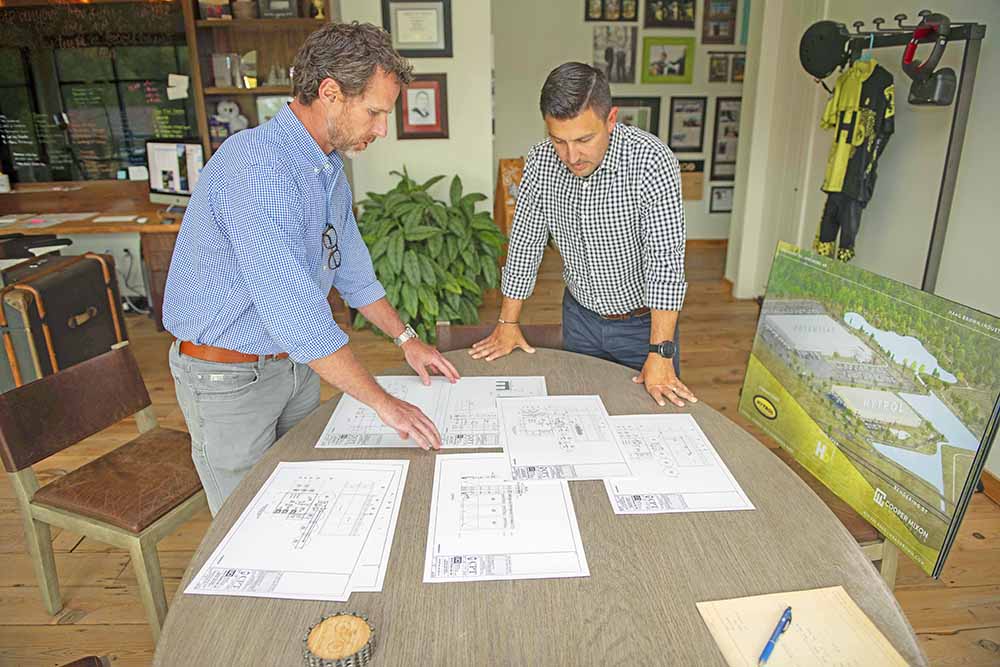 Jeff Armstrong, left, and Joshua Brown of Haag Brown Industrial look over plans and renderings while discussing development of a warehouse and distribution center at the new e-commerce park.