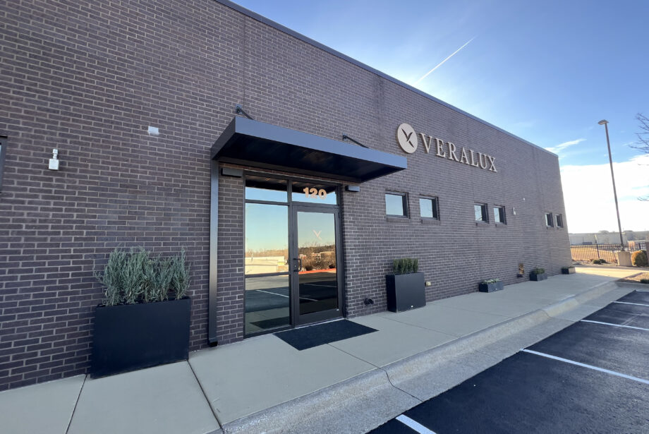 A rectangular brick building with glass double doors and a gold Veralux logo
