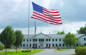 The headquarters building at the Pine Bluff Arsenal in Arkansas, a large, white building with an American flag flying outside the entrance