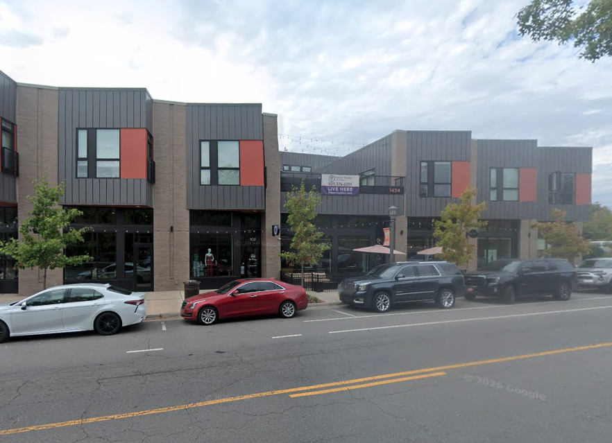 A commercial building with orange details and multiple storefronts