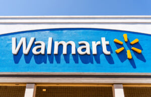 A photo looking up at the "Walmart" sign outside of a Walmart.