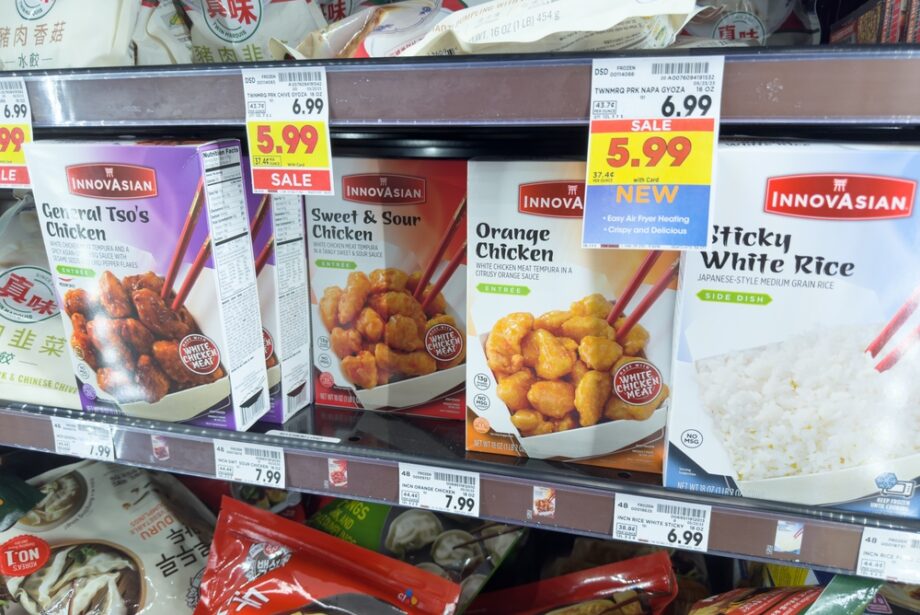 Packages of InnovAsian chicken and white rice on display on the shelf of a grocery store with price tags below each product