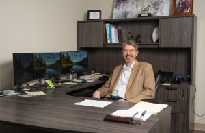 Jerry Borden, an older white man in a tan blazer sitting behind a large desk.