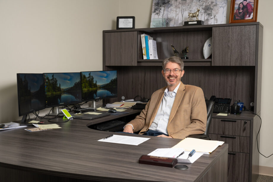 Jerry Borden, an older white man in a tan blazer sitting behind a large desk.